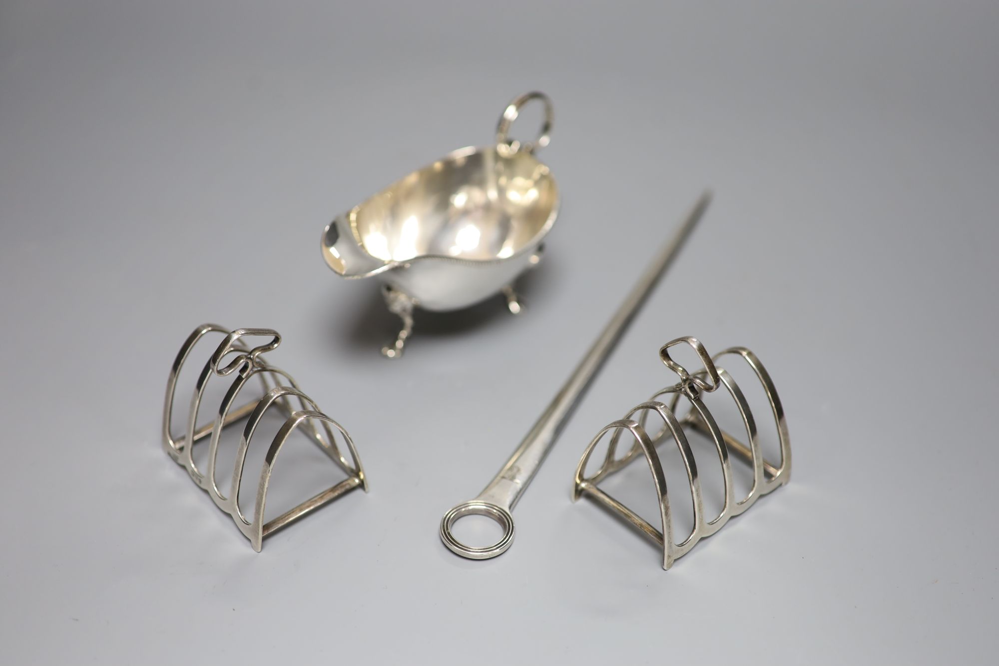 A George III silver meat skewer, Smith & Fearn, London, 1793, a silver sauce boat and a pair of silver toast racks, 9oz.